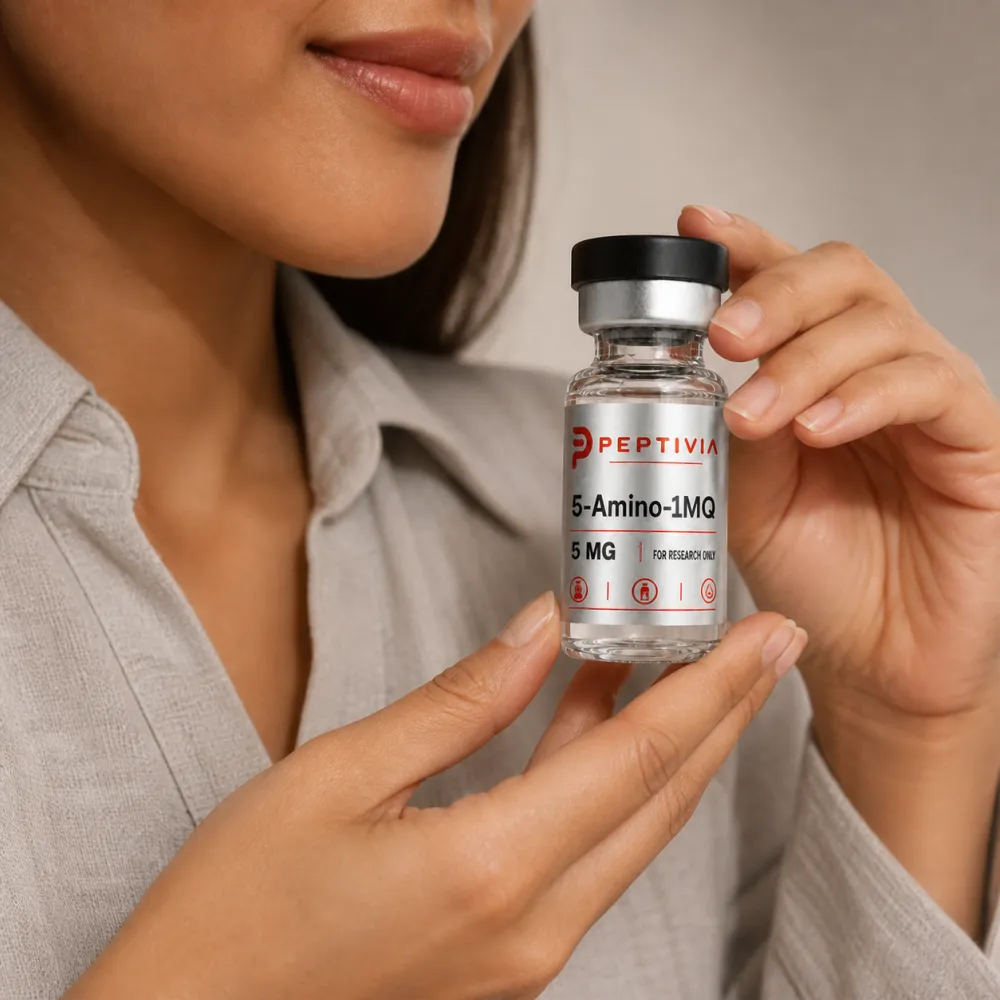 Vial Peptivia 5-Amino-1MQ dipegang di dekat wajah, label perak dengan wordmark merah