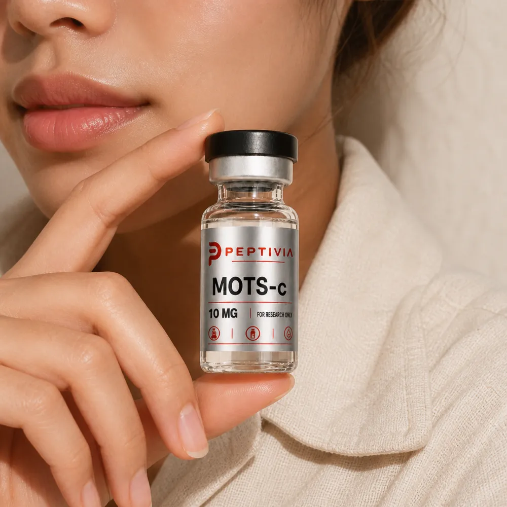 Vial Peptivia MOTS-c dipegang di dekat wajah, label perak dengan wordmark merah